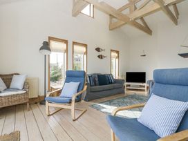 A living room with a sofa and two armchairs at Harbour Lights in Penzance