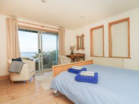 A bedroom with a bed and armchair at Harbour Lights in Penzance