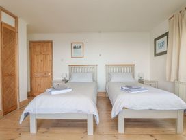 A bedroom with two single beds and nightstands at Harbour Lights in Penzance