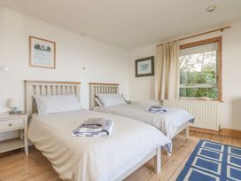 A bedroom with two beds and a window at Harbour Lights in Penzance