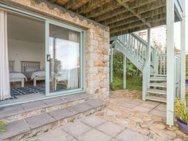 A bedroom with two beds and a sliding door at Harbour Lights Penzance