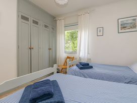 A bedroom with two beds and a wardrobe at Harbour Lights in Penzance
