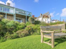 A garden with a bench and house in the background at Harbour Lights in Penzance