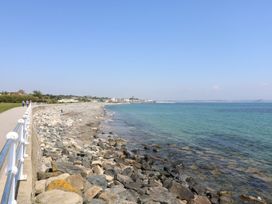 A coastline with rocks and a pathway at Harbour Lights in Penzance