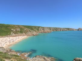 A beach with people and clear water at Harbour Lights in Penzance