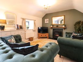 A living room with a sofa and television at The Talkhouse Cottage in Caersws