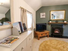 A living room with a television and fireplace at The Talkhouse Cottage in Caersws