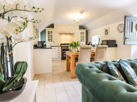 A kitchen with table chairs and appliances at The Talkhouse Cottage in Caersws