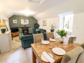 A living room with a dining area and a sofa at The Talkhouse Cottage in Caersws