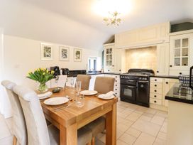 A kitchen with a dining table and chairs at The Talkhouse Cottage in Caersws