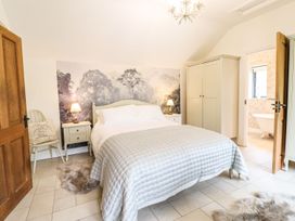 A bedroom with a bed and wardrobe at The Talkhouse Cottage in Caersws