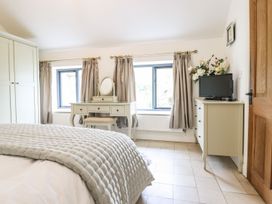 A bedroom with a bed and dresser at The Talkhouse Cottage in Caersws