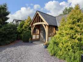 A house with a front door and window surrounded by bushes at The Talkhouse Cottage Caersws