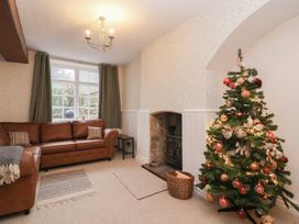 A living room with a sofa and Christmas tree at Waterloo Mill Cottage in Wotton-Under-Edge