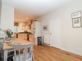 A kitchen with a dining table and assorted appliances at Waterloo Mill Cottage in Wotton-Under-Edge