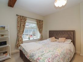 A bedroom with a bed and shelves at Waterloo Mill Cottage in Wotton-Under-Edge