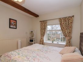 A bedroom with a bed and window at Waterloo Mill Cottage in Wotton-Under-Edge