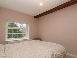 A bedroom with a bed and window at Waterloo Mill Cottage in Wotton-Under-Edge