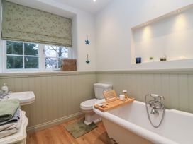 A bathroom with a bathtub, toilet, and sink at Waterloo Mill Cottage Wotton-Under-Edge
