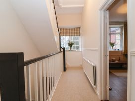 A hallway with a staircase and windows at Waterloo Mill Cottage in Wotton-Under-Edge