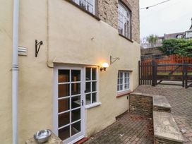 An outdoor area with a door and windows at Waterloo Mill Cottage in Wotton-Under-Edge