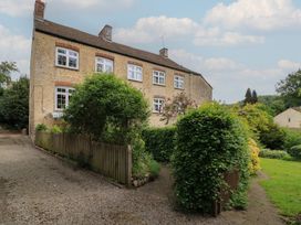 A house with windows and garden at Waterloo Mill Cottage in Wotton-Under-Edge