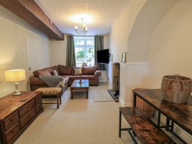 A living room with a sofa, coffee table, and television at Waterloo Mill Cottage in Wotton-Under-Edge