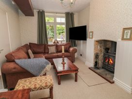 A living room with a sofa and fireplace at Waterloo Mill Cottage in Wotton-Under-Edge