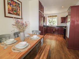 A kitchen with a dining area featuring a wooden table and chairs at Waterloo Mill Cottage Wotton-Under-Edge