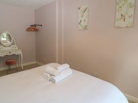 A bedroom with a bed and a vanity at Waterloo Mill Cottage in Wotton-Under-Edge