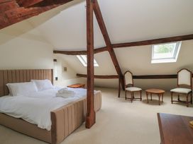 A bedroom with a bed and two chairs at Waterloo Mill Cottage Wotton-Under-Edge