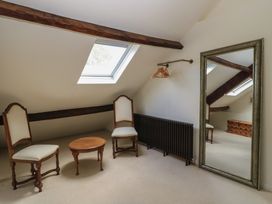 A bedroom with chairs and a mirror at Waterloo Mill Cottage in Wotton-Under-Edge