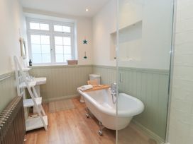 A bathroom with a bathtub, sink, and shower at Waterloo Mill Cottage in Wotton-Under-Edge