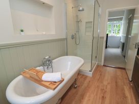 A bathroom with a bathtub and shower at Waterloo Mill Cottage Wotton-Under-Edge