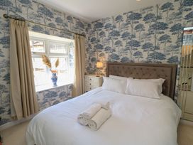 A bedroom with a bed and window at Waterloo Mill Cottage in Wotton-Under-Edge