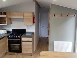 A kitchen with cabinets, stove, and toaster at Caravan Thorness Bay Holiday Park, Thorness Lane