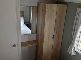 A bedroom with a wardrobe and bed at Caravan Thorness Bay Holiday Park Thorness Lane