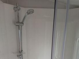 A shower with a silver shower head and control in a bathroom at Caravan Thorness Bay Holiday Park Thorness Lane