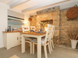 A dining room with a table and chairs at Driftwood Cottage in Helston