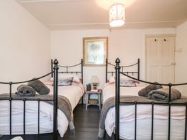 A bedroom with twin beds and a nightstand at Driftwood Cottage in Helston