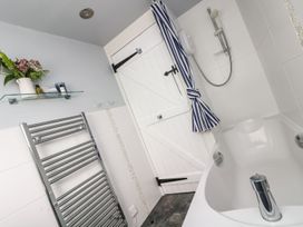 A bathroom with a bath tub and shower at Driftwood Cottage in Helston