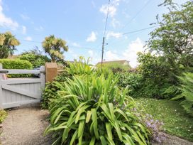 A garden with plants and a gate at Driftwood Cottage in Helston