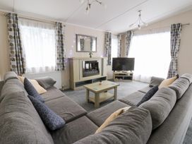 A living room with a sofa and television at Beechwood Lodge
