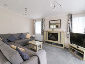 A living room with a sofa and television at Beechwood Lodge