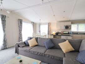 A living room with a sofa and dining area at Beechwood Lodge