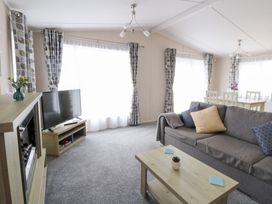 A living room with a sofa and a television at Beechwood Lodge