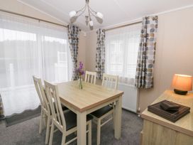 A dining room with a table and chairs at Beechwood Lodge