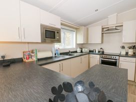 A kitchen with cabinets and kitchen appliances at Beechwood Lodge