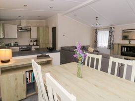 A living room with a dining table and sofa at Beechwood Lodge