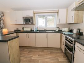 A kitchen with a microwave, sink, toaster, and stove at Beechwood Lodge 